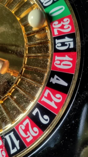 Casino roulette wheel with ball and numbers on a dark background, close-up. Vertical video