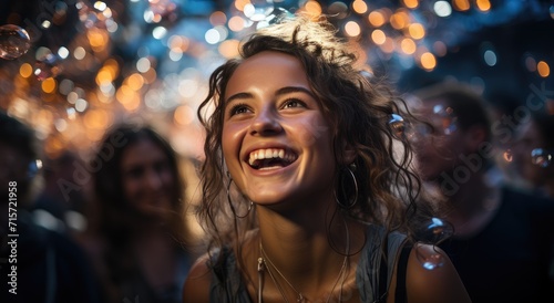 A joyous woman, adorned in stylish clothing, laughs under the night sky as her hair dances in the wind, her radiant smile illuminated by the soft glow of the outdoor lights