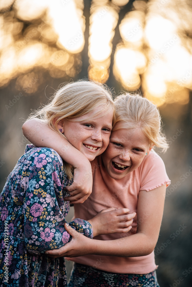 2 girls hugging and smiling with each other 2 girls hugging and smiling with each other