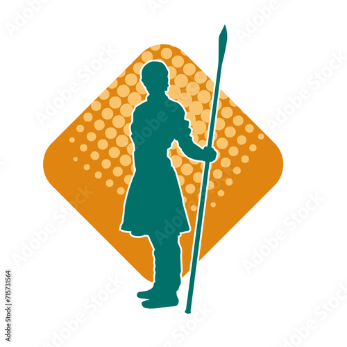 Silhouette of a wushu martial artist in action pose with a spear weapon. Silhouette of a fighter carrying a spear weapon.