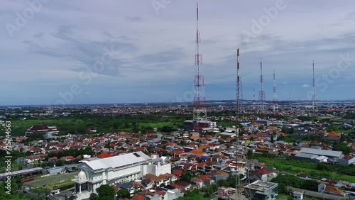 Soaring above West Surabaya, Indonesia, this drone footage captures the vibrant tapestry of kampung life. Sunlight glints off tin roofs photo