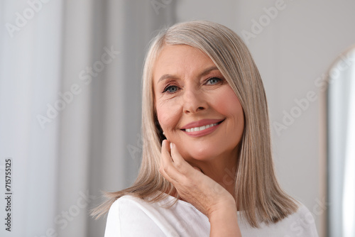 Portrait of beautiful middle aged woman indoors. Space for text