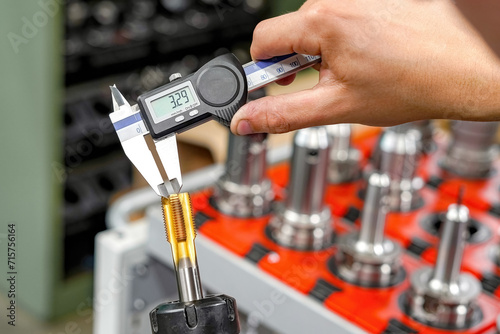 Checking the dimensions of the cutting tool with a caliper for metalworking CNC milling and turning machines.