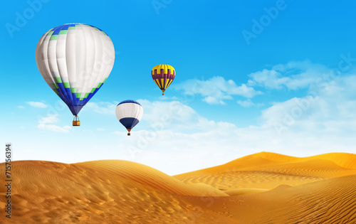 Bright hot air balloons flying in blue sky over sandy desert