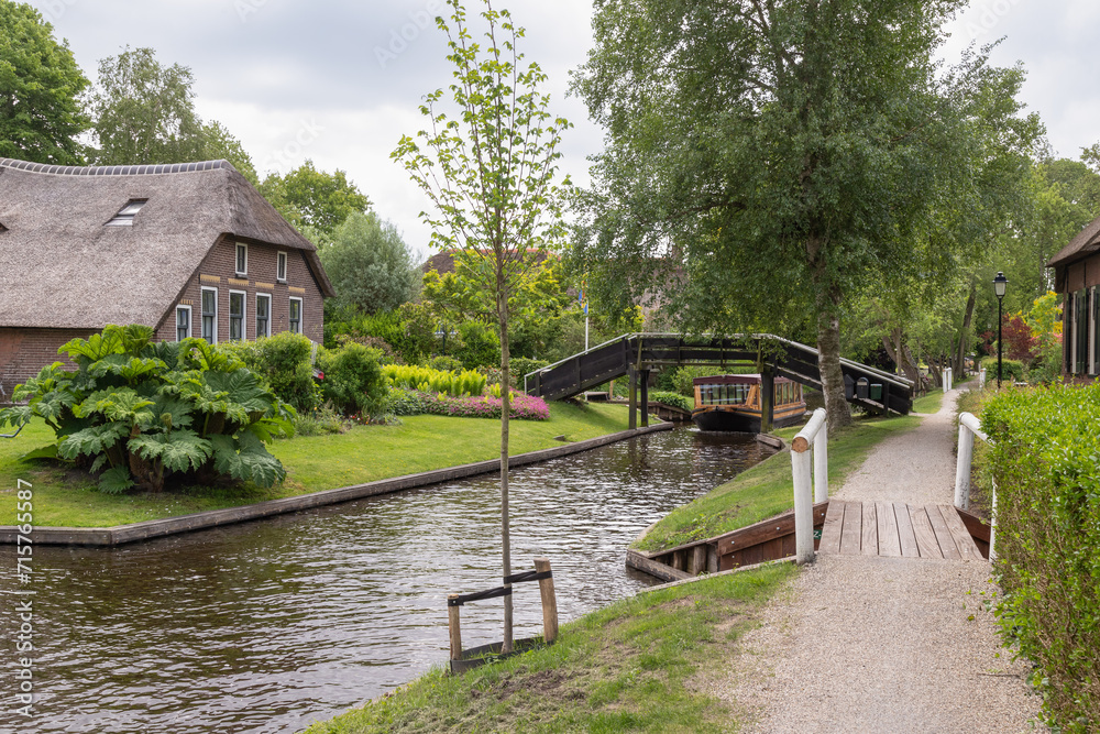 Rural village of Giethoorn with picturesque houses with thatched roofs and narrow wooden bridges. Rural village of Giethoorn with picturesque houses with thatched roofs and narrow wooden bridges.