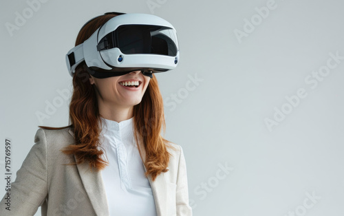Smiling businesswoman in casual wear dons a VR helmet. © OLGA