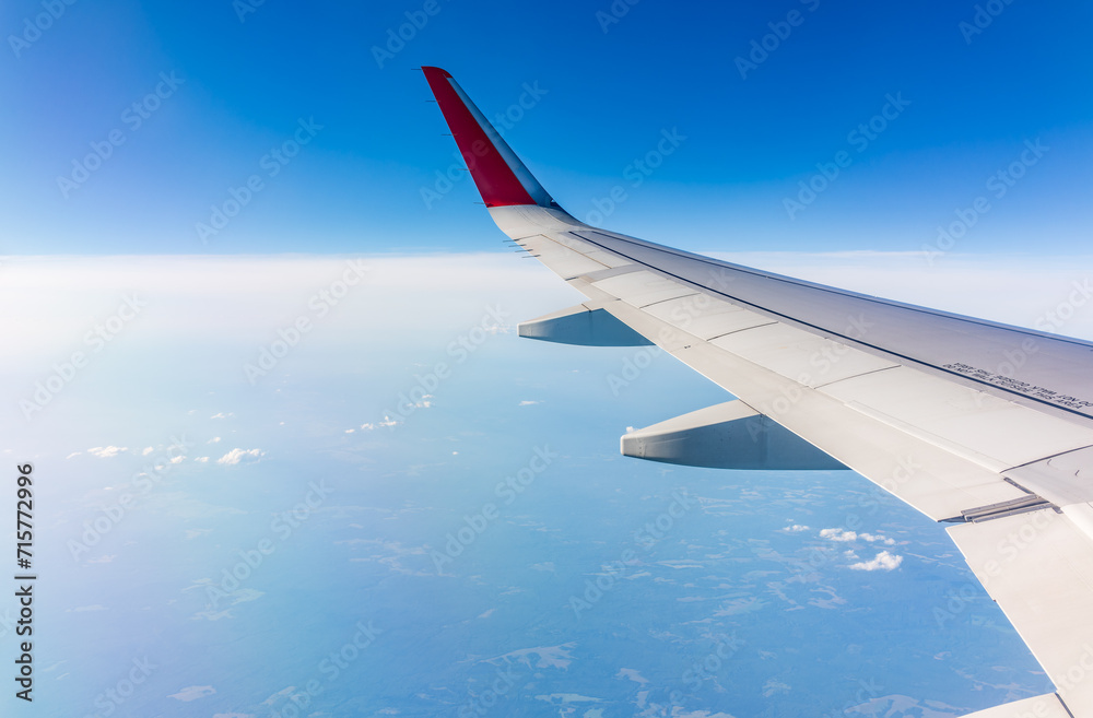 View from the airplane window at a beautiful cloudy sky and the airplane wing