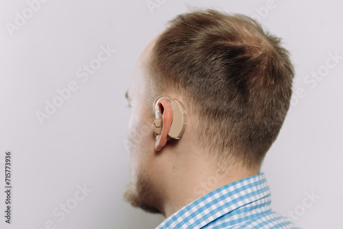 man with a hearing aid on a white background in a shirt without a face