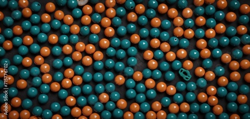  a close up of a bunch of balls with a green and orange one in the middle of the balls and the other blue and orange one in the middle of the balls.