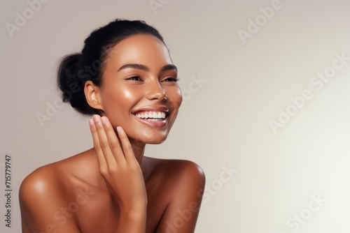 Beauty studio background with empty space. Beautiful smiling young woman with soft glow skin and bare shoulders.