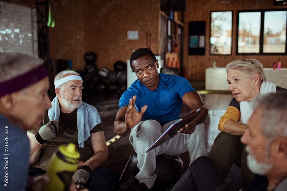 © Davor - Senior people talking to trainer after gym workout
