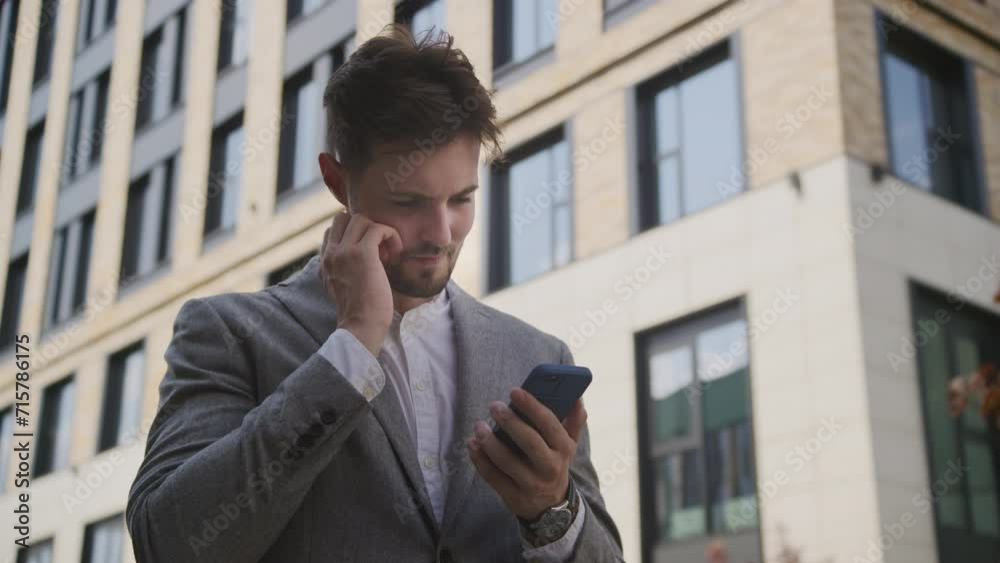 Young Businessman Interacting with Smartphone in City Young Businessman Interacting with Smartphone in City