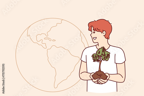 Man cares about environment holds sprout of tree, standing near planet and calls for planting new forests. Environment activist advocates for refusing to cut down green spaces that release pure oxygen