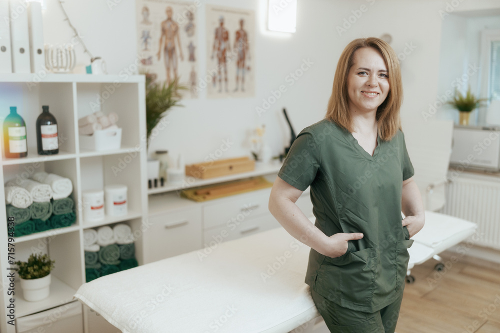 happy female medical massage therapist looking at camera