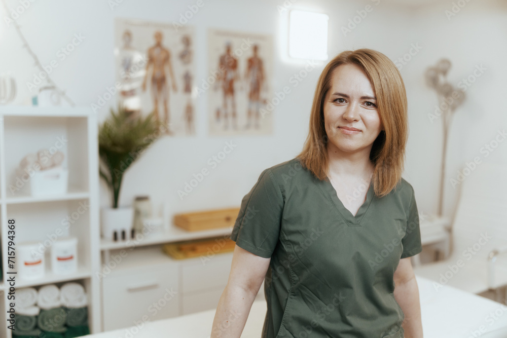 female massage therapist in massage cabinet looking at camera female massage therapist in massage cabinet looking at camera
