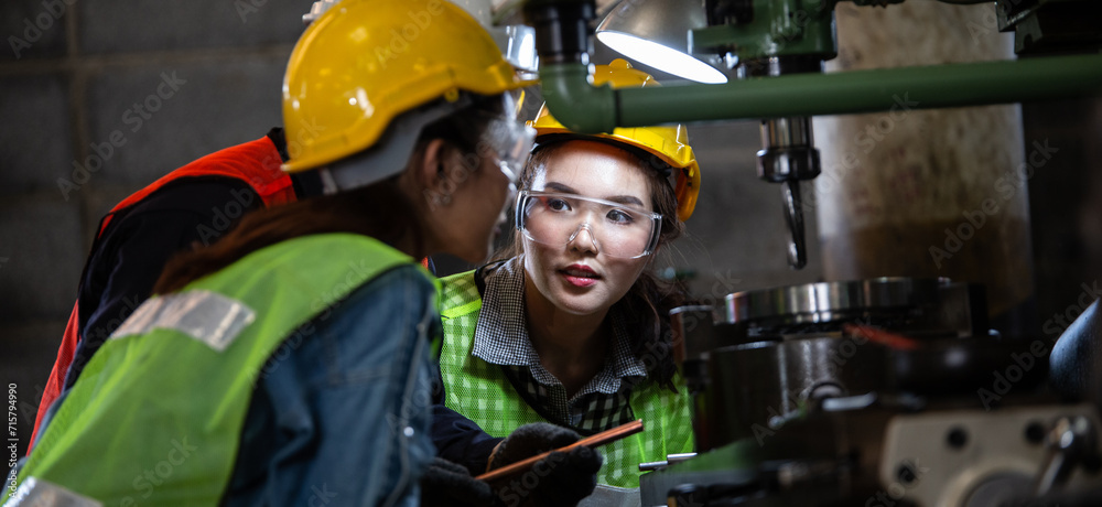 Asian foreman manager showing case study of factory machine to two engineer trainee young woman in protective uniform. teamwork people training and working in industrial manufacturing business Asian foreman manager showing case study of factory machine to two engineer trainee young woman in protective uniform. teamwork people training and working in industrial manufacturing business
