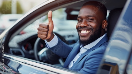 African American businessman showing thumb up while on expensive ca, New car, Car insurance concept. © Oulaphone