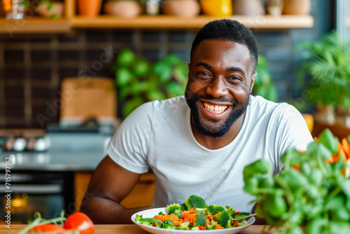 happy young black man holding salad. healthy eating. vegetable salad