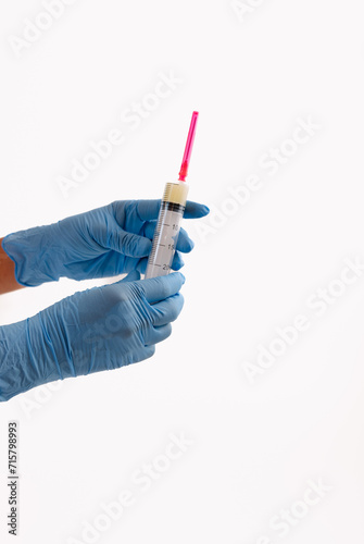 Close up of hands of anesthetist manipulating syringe with medical solution to apply medically to patient
