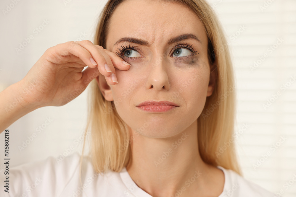 Sad woman with smeared mascara crying indoors, closeup Sad woman with smeared mascara crying indoors, closeup