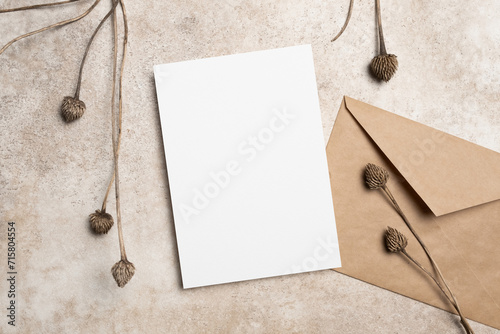 Blank invitation or greeting card mockup with envelope and botanical decor, copy space