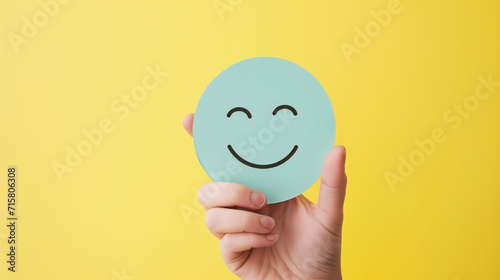 Hand holding paper cut smile face, positive thinking, mental health assessment , world mental health day concept, generative ai photo