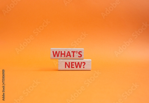What is new symbol. Concept word What is new on wooden blocks. Beautiful orange background. Business and What is new concept. Copy space