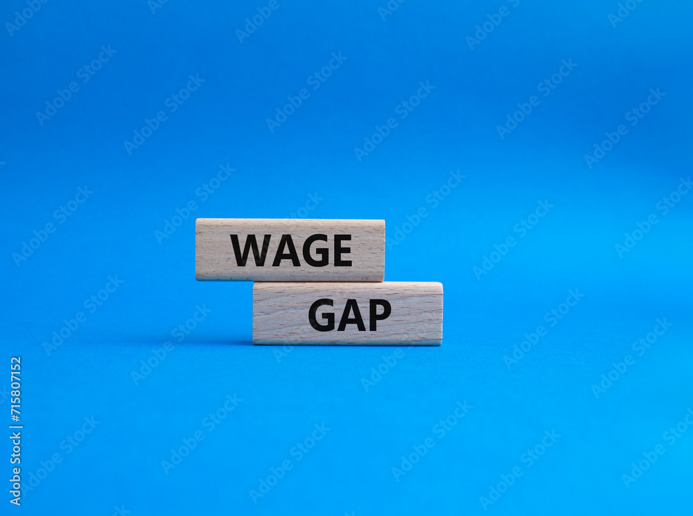 Obraz premium Wage Gap symbol. Concept words Wage Gap on wooden blocks. Beautiful blue background. Business and Wage Gap concept. Copy space.