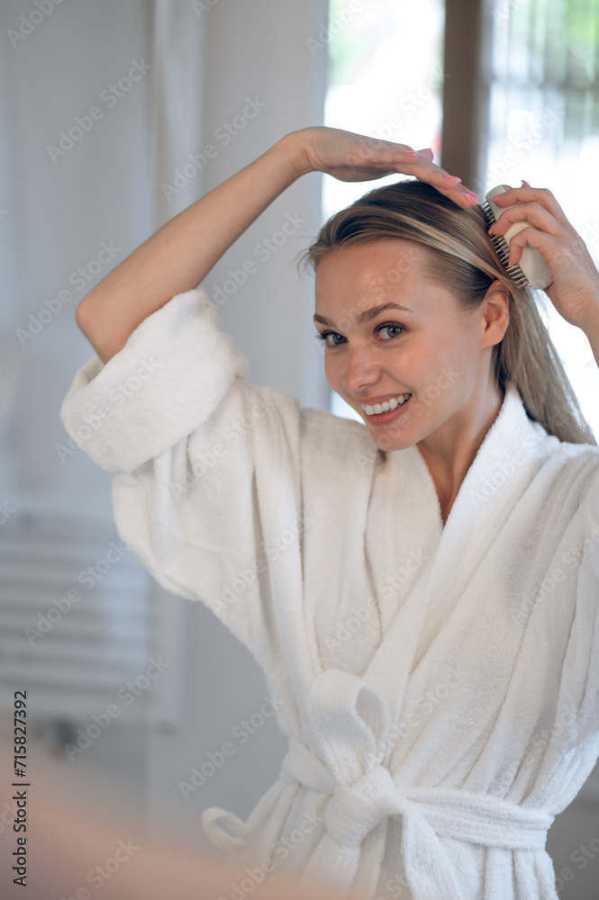 Fototapeta premium Blonde young woman making hair