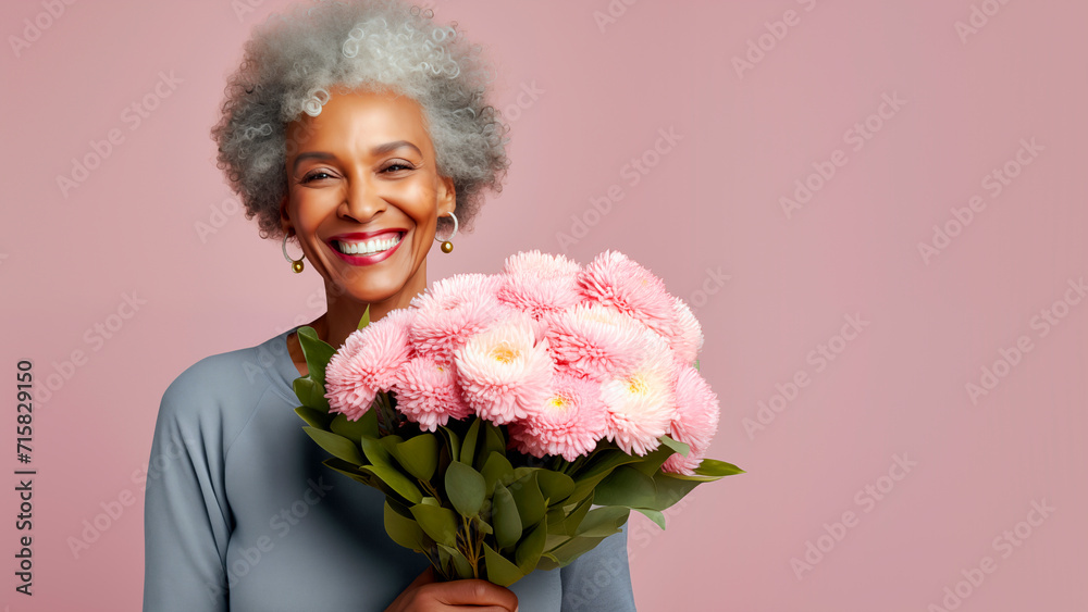 A smiling beautiful elderly woman with a bouquet of flowers in her hands. A festive concert for Mother's Day, women's Day, and birthday. A smiling beautiful elderly woman with a bouquet of flowers in her hands. A festive concert for Mother's Day, women's Day, and birthday.