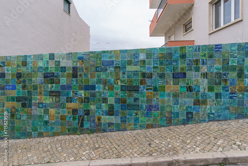 Wall besides street covered with green, blue and turquoise tiles, Lisbon, Portugal