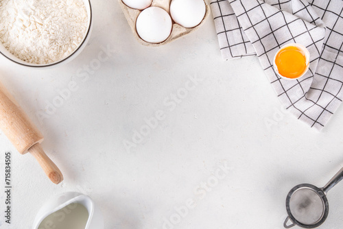Empty space baking background with bakery ingredients - flour, milk, eggs, rolling pin. Simple pastry baking flat lay top view border photo