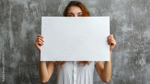 Woman holding an empty sign board in clean backdrop with a big empty space, Generative AI. photo