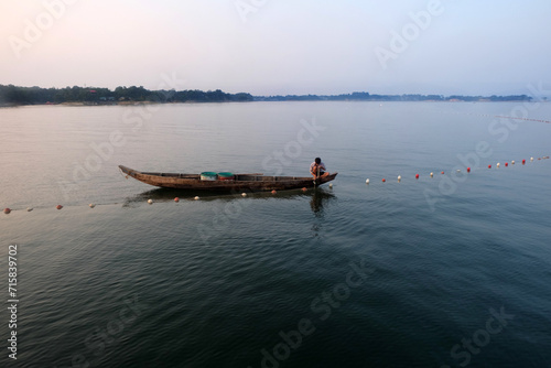 A fisherman is fishing in Kaptai Lake in the afternoon. The scene is amazing.