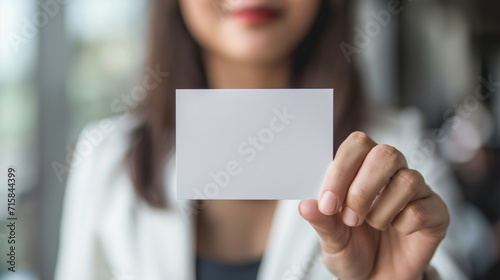 Business woman holds a clean business card in her hands, close-up
