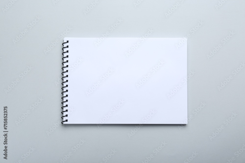 One notebook on light grey background, top view. Space for text One notebook on light grey background, top view. Space for text