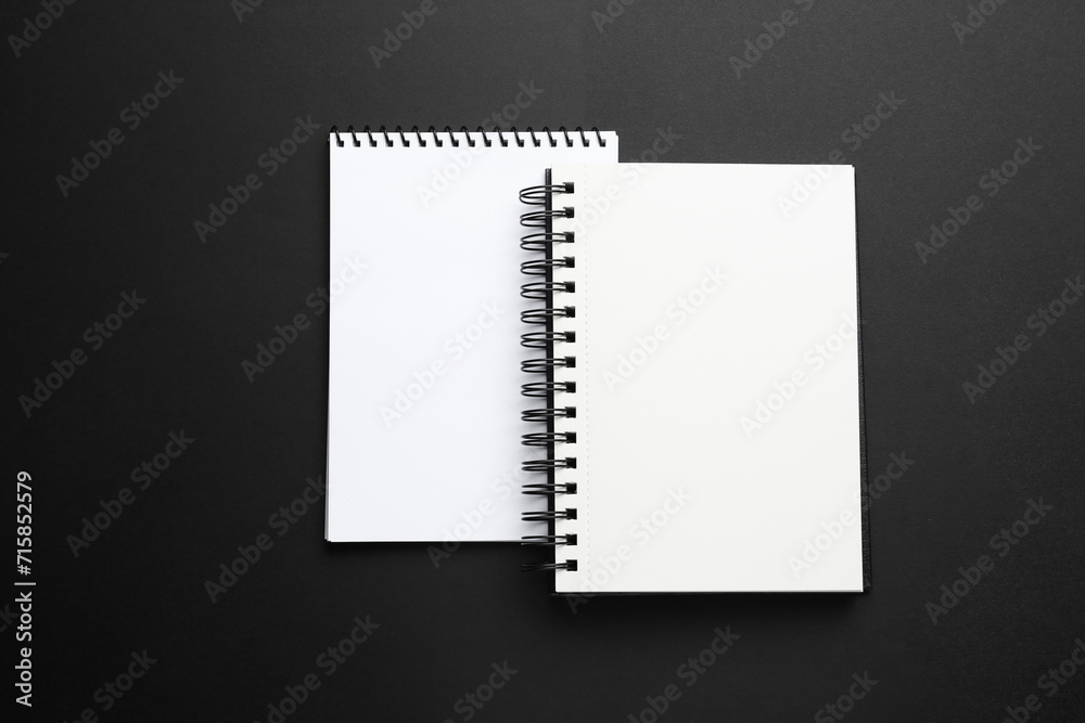 Two notebooks on black background, top view Two notebooks on black background, top view