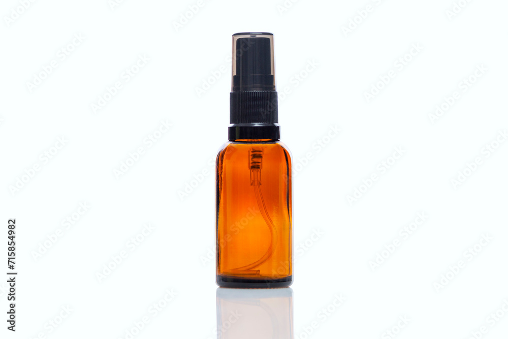 Empty dark glass spray bottle. Perfumes and essential oils. Close-up. Isolated on a white background. Space for text.
