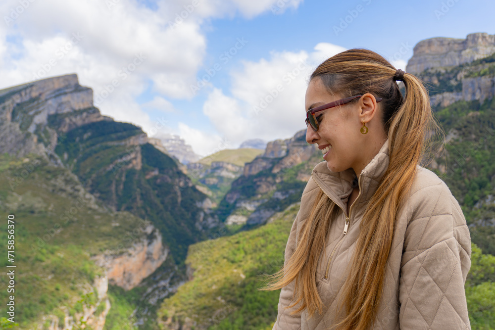 Woman with sunglasses and pigtails smiles sideways in Anisclo Canyon