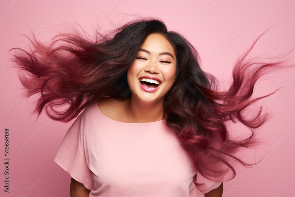 Pretty Asian plus size woman with happy smile in front of pink studio background Pretty Asian plus size woman with happy smile in front of pink studio background