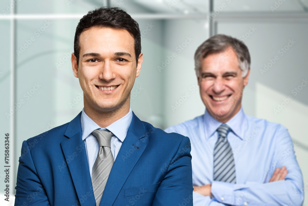Confident businessmen smiling in office Confident businessmen smiling in office