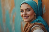 Smiling woman against a colorful wall, wearing a headscarf, beautiful woman, turquoise colors