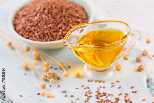 Brown linen seeds, flaxseed vegetable oil on white wooden background. Healthy super food
