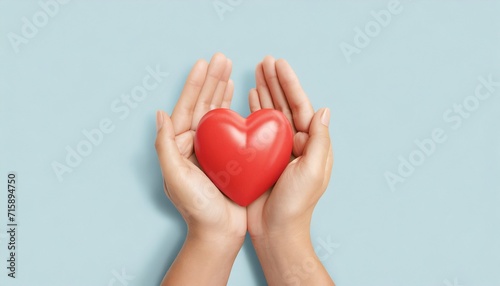adult hands around red heart on light blue pastel background health care organ donation family life insurance world heart day world health day praying concept