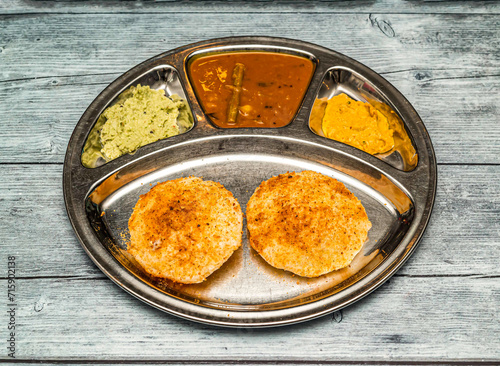 podi idli with curry thali served in dish isolated on wooden table top view of indian spicy food photo