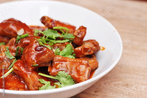 Chinese Red Soup Pork Ribs served on a white plate, a popular Chinese dish, made from sliced pork ribs and tomato sauce.