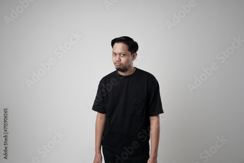 Portrait of a man making a silly funny face, showing a funny brainless silly facial expression posing with a stupid smile, playing around. An isolated indoor studio shot on a gray background photo