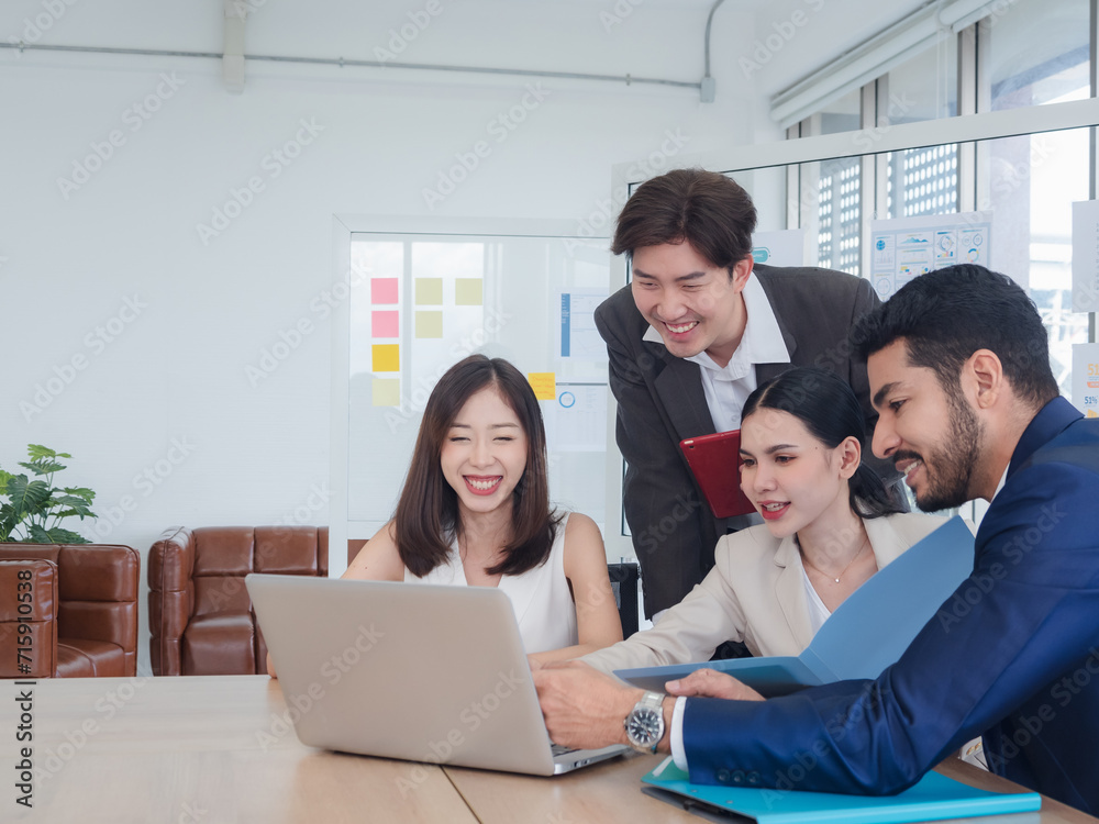 Portrait business team woman and man Asian group meeting sitting on desk looking computer hand holding laptop notebook ready for idea new project happy working online sale inside the home office Portrait business team woman and man Asian group meeting sitting on desk looking computer hand holding laptop notebook ready for idea new project happy working online sale inside the home office