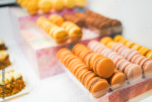Assorted macarons neatly arranged in a display box at a bakery.