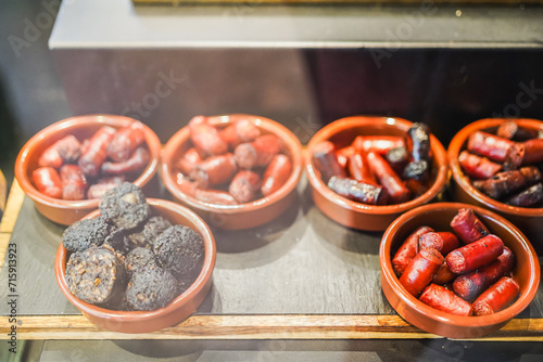 Various traditional Spanish sausages served in terracotta dishes. photo